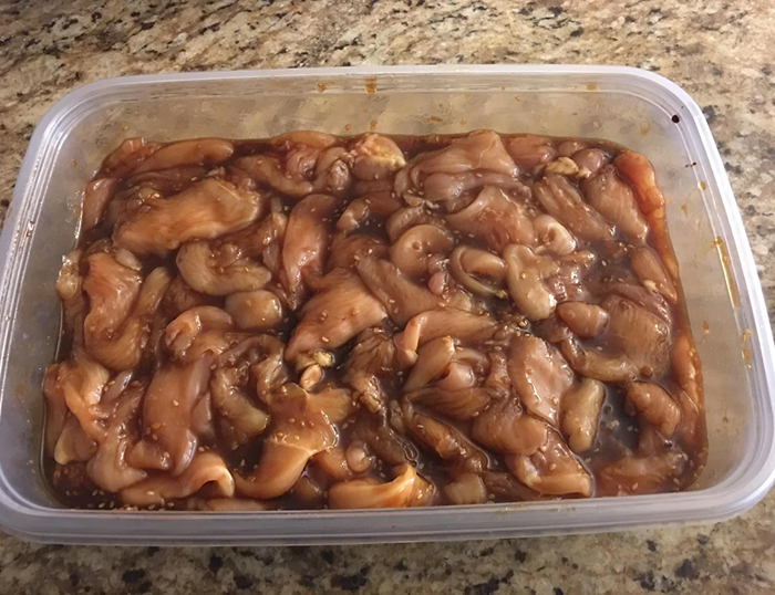 Chicken marinating in sauce in plastic container for cooking myths