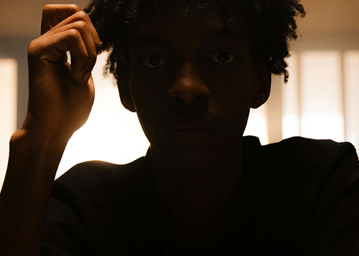 Shadowed face of a young man in low light with intense expression