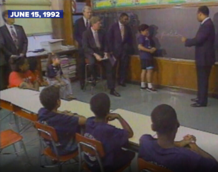 A classroom with adults and children, depicting a scene related to celebrity scandals.