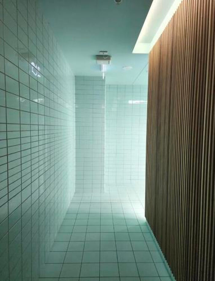 A long, tiled corridor with a light at the end, creating a haunting liminal space.