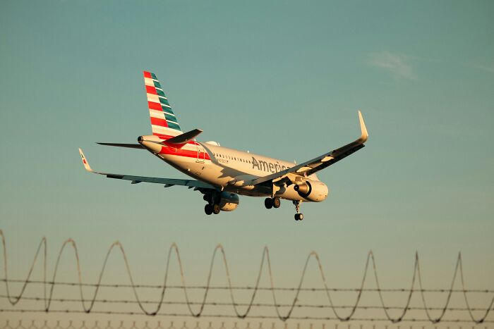 An American Airlines plane descending against a clear sky, highlighting plane interactions.