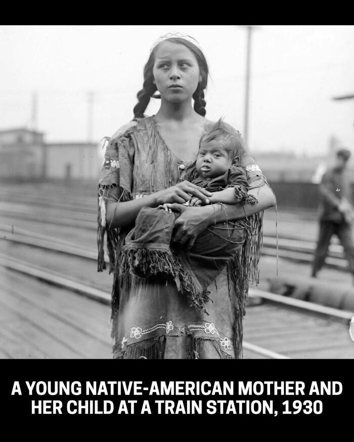 A young Native-American mother and child at a train station, a rare historical photo from 1930.