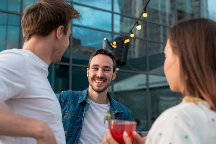 Group of friends chatting and laughing outdoors in casual setting