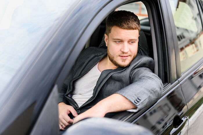 A man in a car, looking out the window, showing disturbing things about friends.