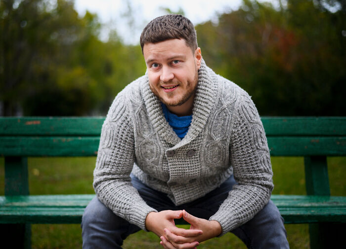Man smiling on park bench reflecting on family secrets