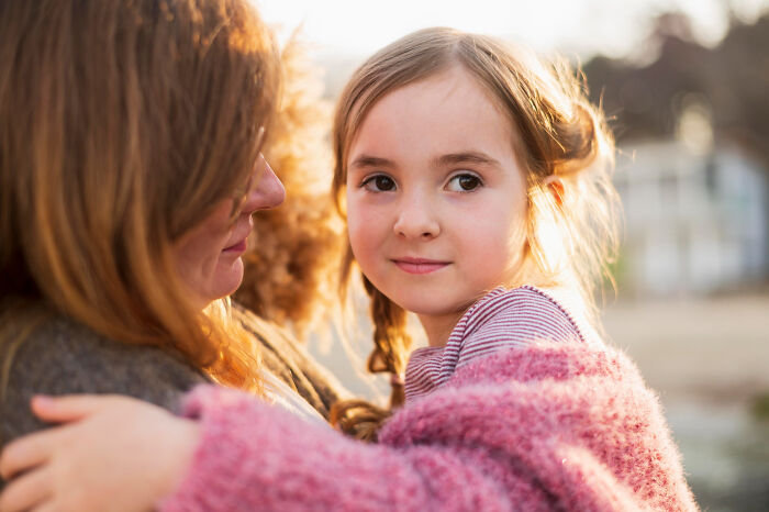 Young child being embraced by adult capturing innocence amid family secrets