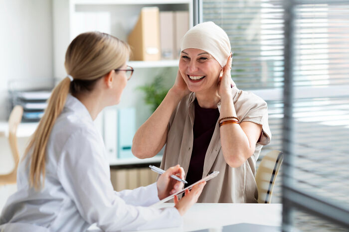 Smiling woman with headscarf consulting with female doctor in office