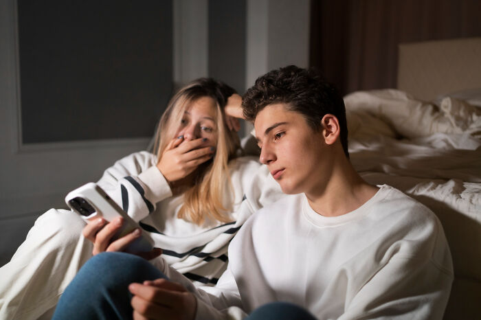 Two young people looking at a phone with disturbed expressions, showing things people learned about their friends.