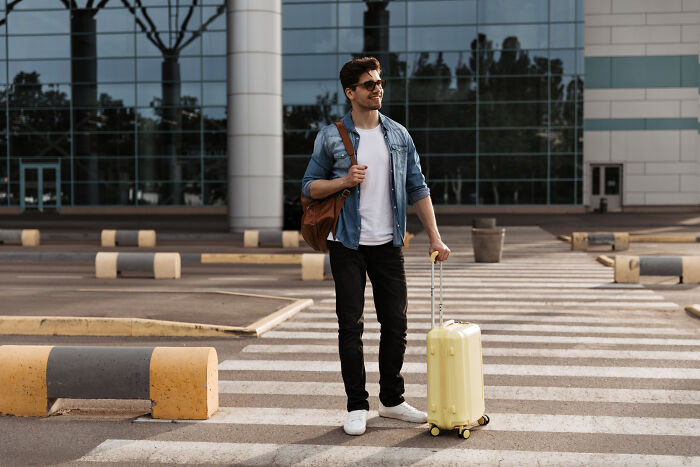 Man standing with suitcase outside modern building modern world audacity