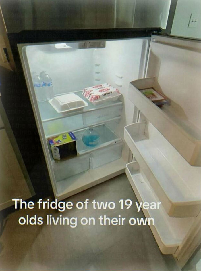 An almost empty refrigerator with only a few items inside, illustrating the Chaotic and Unhinged Pics of young adults living alone.