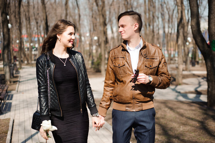 Happy couple holding hands and smiling outside, opposite of unhinged breakup excuses