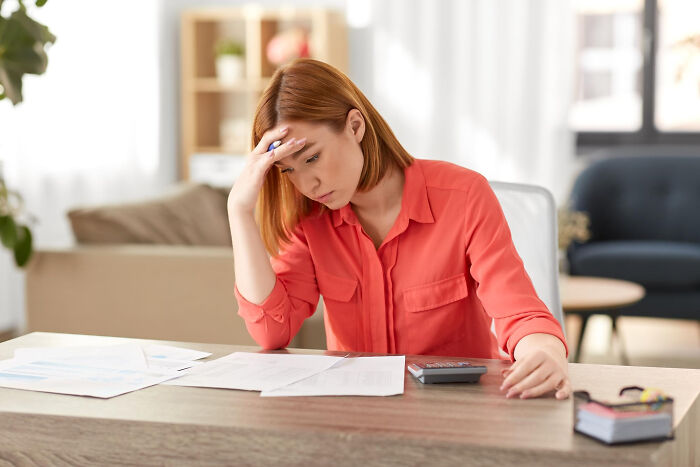 Woman stressed over bills and finances at home desk