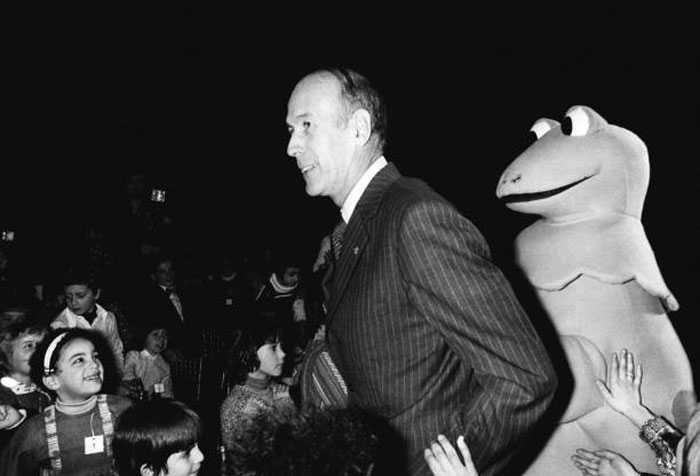 Black and white photo of world leader greeting children at event