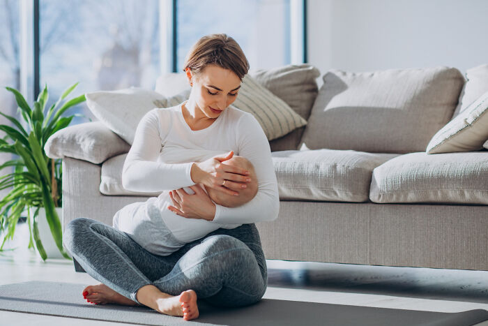 Mother breastfeeding baby showing natural human body nurturing