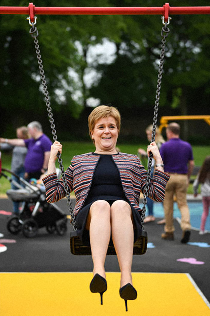 Female world leader enjoying a swing at a park playground