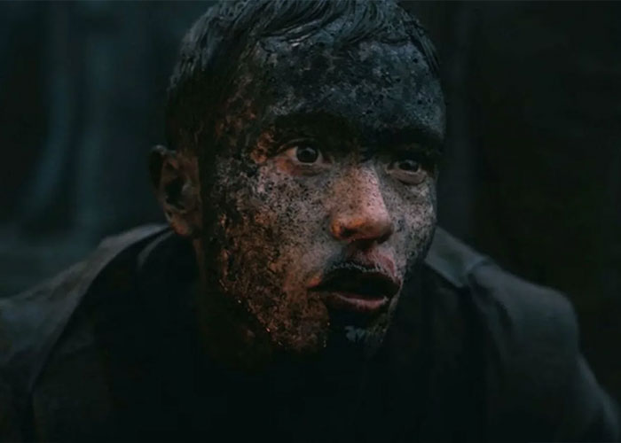 Elliot Page covered in dark grime, revealing a shredded physique, hinting at his boxing fitness.
