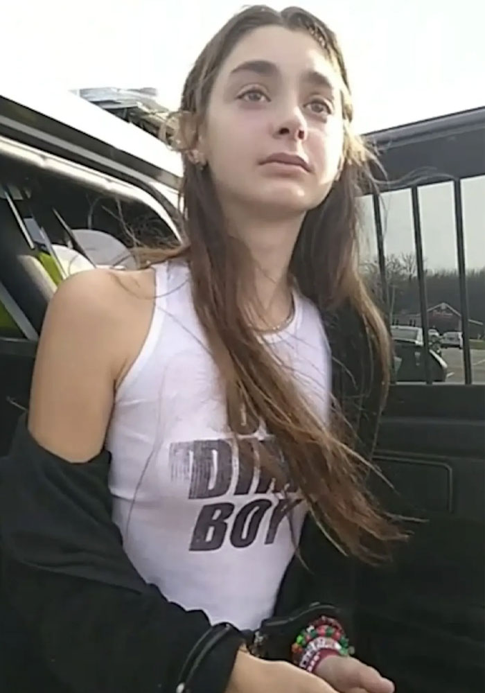 Mackenzie Shirilla outside looking away wearing a white tank top and bracelets Mackenzie Shirilla outside looking away wearing a white tank top and bracelets