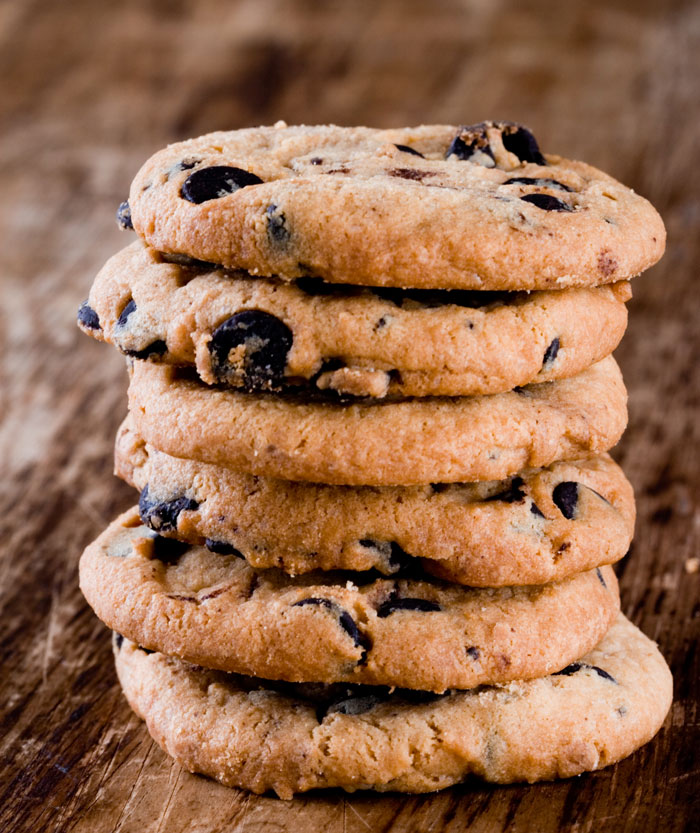 Stack of chocolate chip cookies on a wooden surface