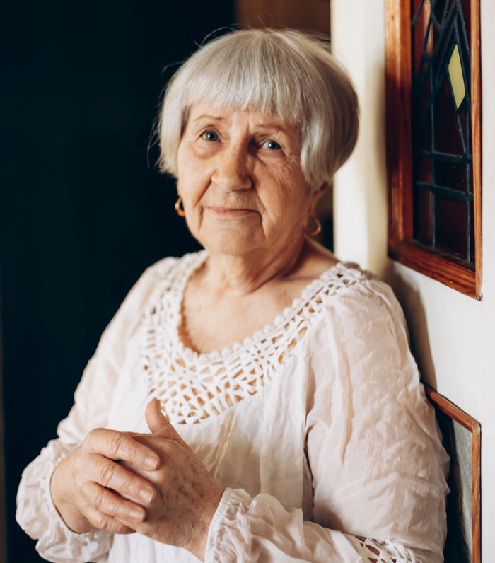 Elderly woman looking thoughtful indoors