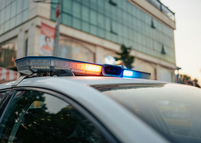 Police car with flashing lights outside a building Police car with flashing lights outside a building