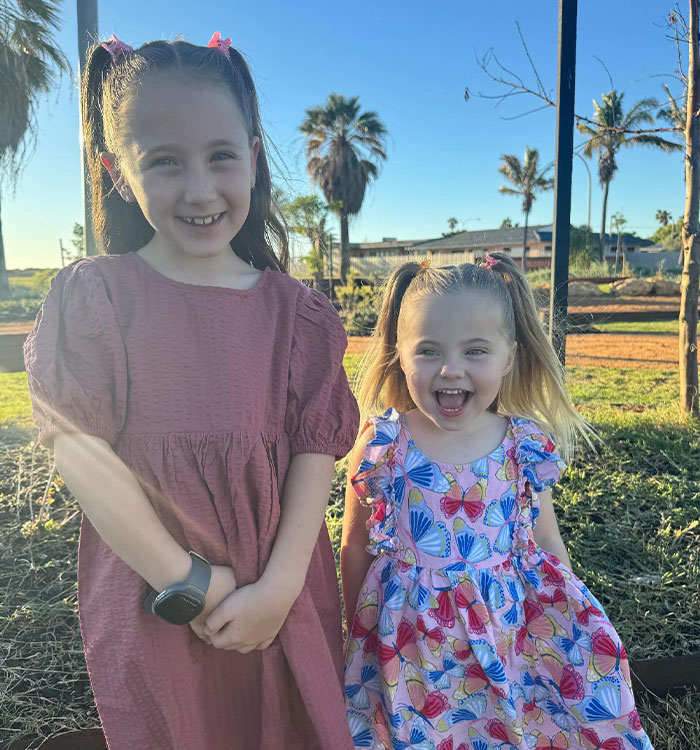 Two young girls smiling outdoors in bright daylight Two young girls smiling outdoors in bright daylight