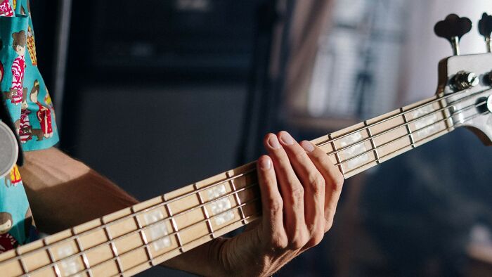 Close-up of hand playing bass guitar symbolizing mind-bending dilemmas
