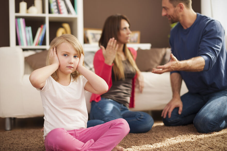 Child covering ears while parents argue in family conflict resolution scene