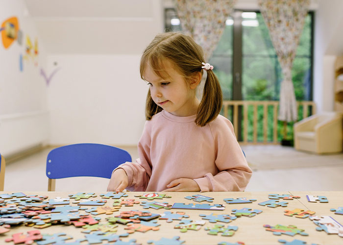 A young girl doing a jigsaw puzzle, related to new research on autism and changing how we understand the condition. A young girl doing a jigsaw puzzle, related to new research on autism and changing how we understand the condition.