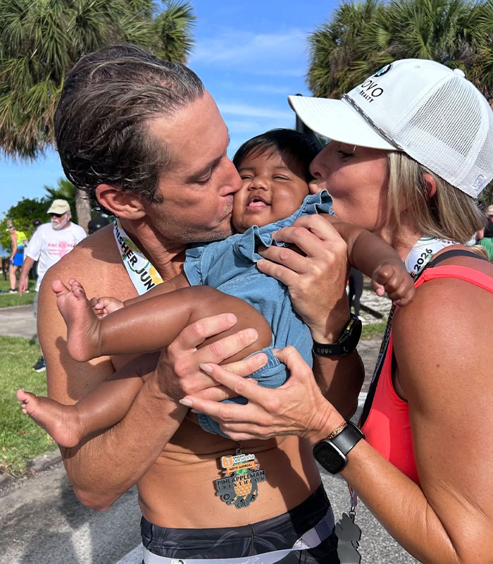 Happy parents kissing their baby, who was born to the wrong parents after an IVF mix-up. Happy parents kissing their baby, who was born to the wrong parents after an IVF mix-up.
