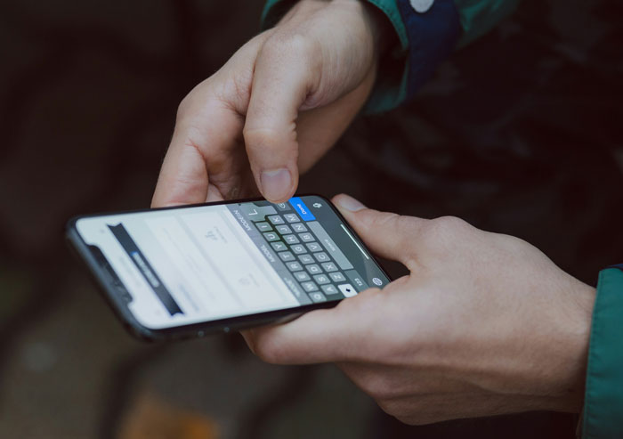 Hands holding and typing on a modern smartphone, revealing heartwarming and heartbreaking things on late parents' phones.
