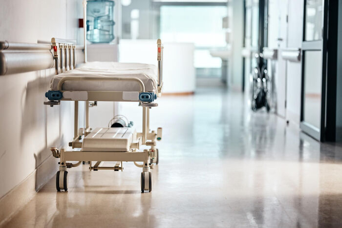 An empty hospital gurney in a brightly lit hallway, representing disturbing things people learn about friends and seeing them differently.