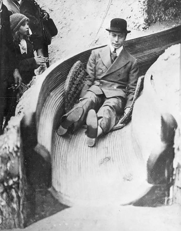 Wholesome world leader sliding down wooden slide in vintage black and white photo