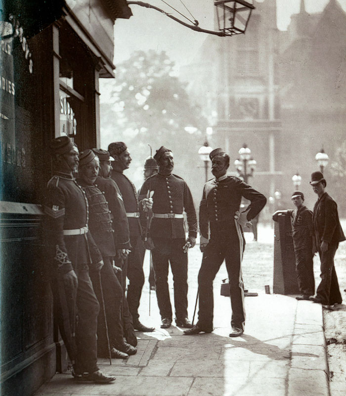 Group of vintage-uniformed men standing and talking on city street Group of vintage-uniformed men standing and talking on city street