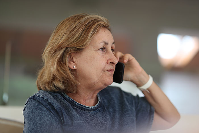 Older woman talking on phone looking concerned