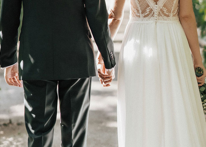 A couple holding hands, representing a honeymoon trip, relating to the woman's drunken tantrum story.