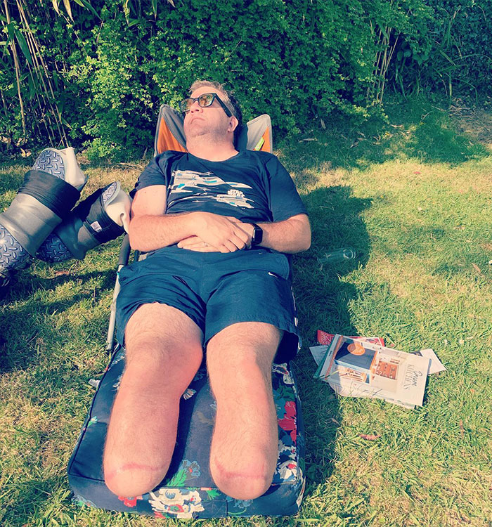 Man with double leg amputation relaxing outdoors near prosthetic legs Man with double leg amputation relaxing outdoors near prosthetic legs