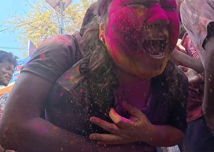 Korean man covered in colorful powder during Holi festival in India