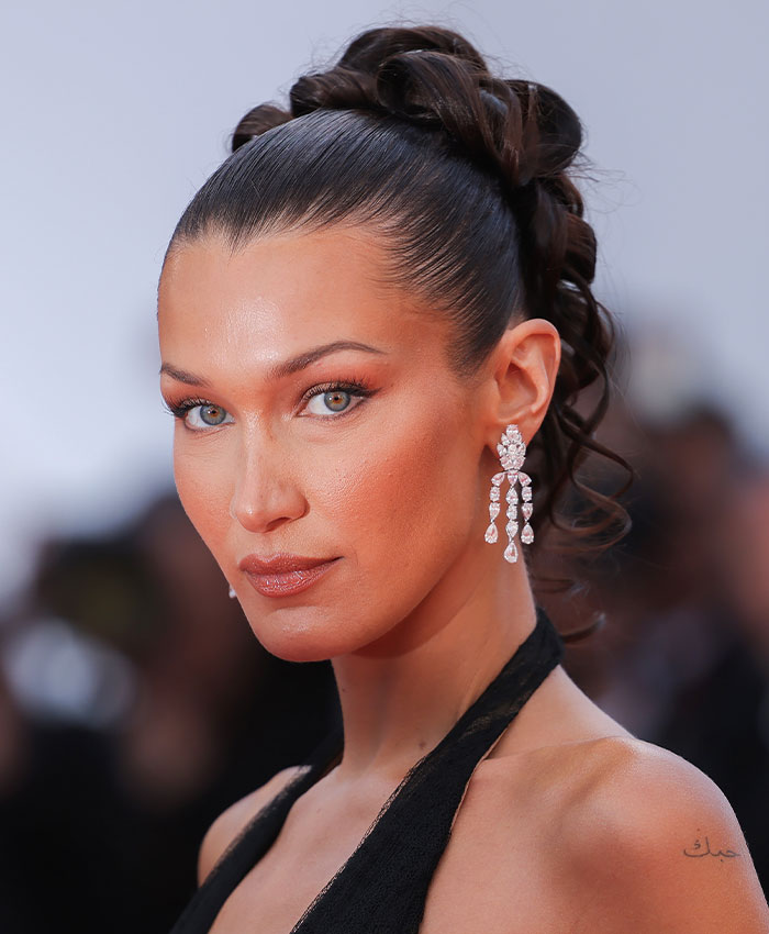 Model with sleek hairstyle and makeup highlighting facial features and bone structure