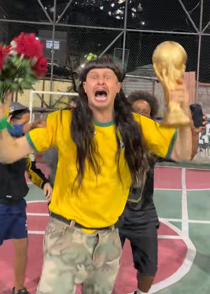Oliver Tree excitedly holding a trophy and bouquet on a basketball court Oliver Tree excitedly holding a trophy and bouquet on a basketball court