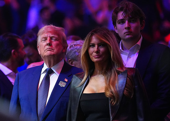 Donald Trump, Melania Trump, and Barron Trump at UFC appearance under dramatic lighting Donald Trump, Melania Trump, and Barron Trump at UFC appearance under dramatic lighting