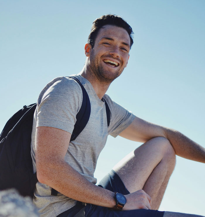 A man smiling outdoors, challenging common myths about men.