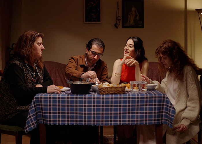 A family gathered around a dinner table, discussing good but socially unacceptable advice.