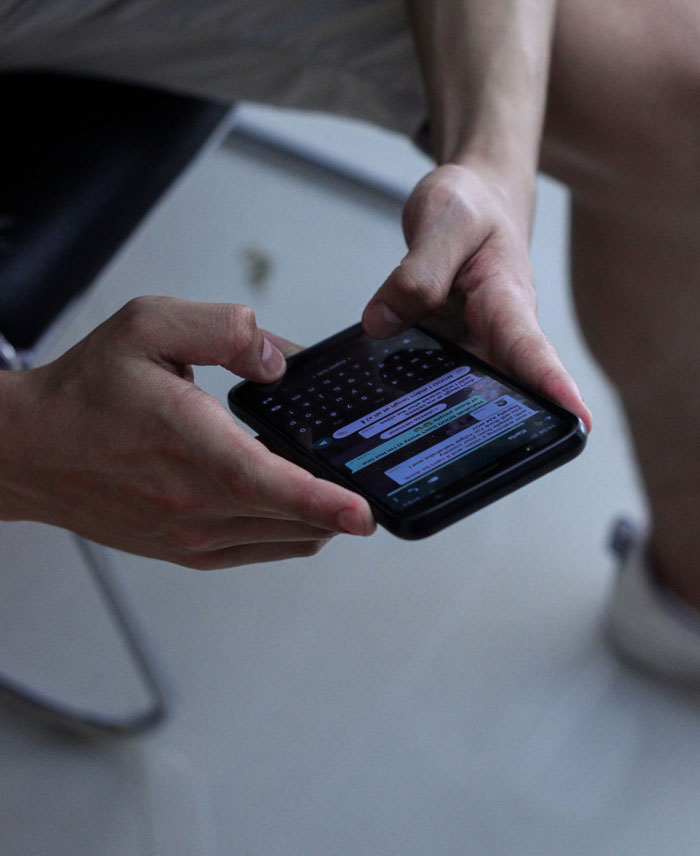 Close-up of hands typing on a smartphone, discovering heartwarming and heartbreaking things on late parents' phones.