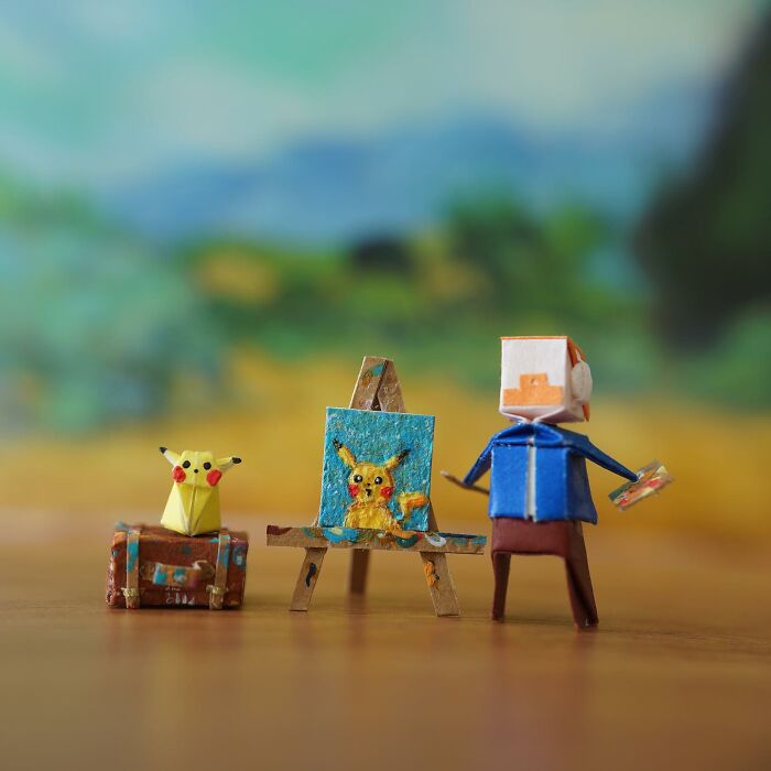 A miniature paper artist painting a detailed Pikachu on an easel, with another paper Pikachu sitting on a tiny trunk next to it, showcasing immense detail.