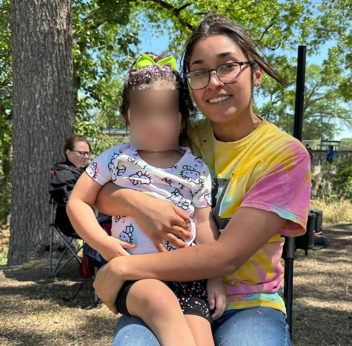 A young mom of 5 smiling while holding a child, before the fatal attack by the Texas Sisters.