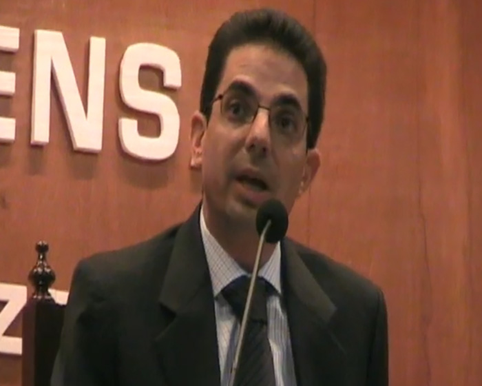 Man in suit speaking at microphone about parents accused in child vanishing