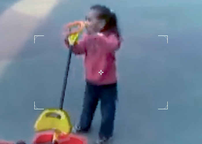Blurry image of 4-year-old girl with toy in outdoor area