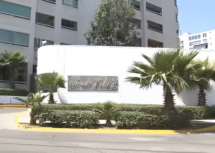Entrance of modern apartment complex with palm trees