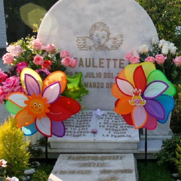 Grave decorated with flowers and windmills for a 4-year-old girl found lifeless under her bed