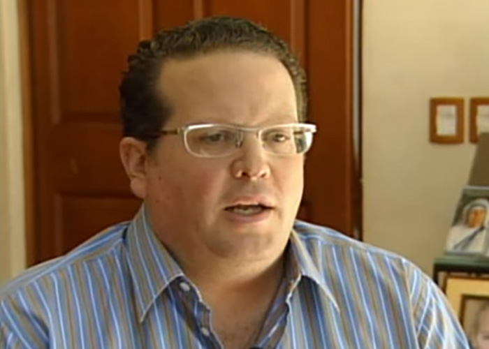 Man wearing glasses speaking inside room